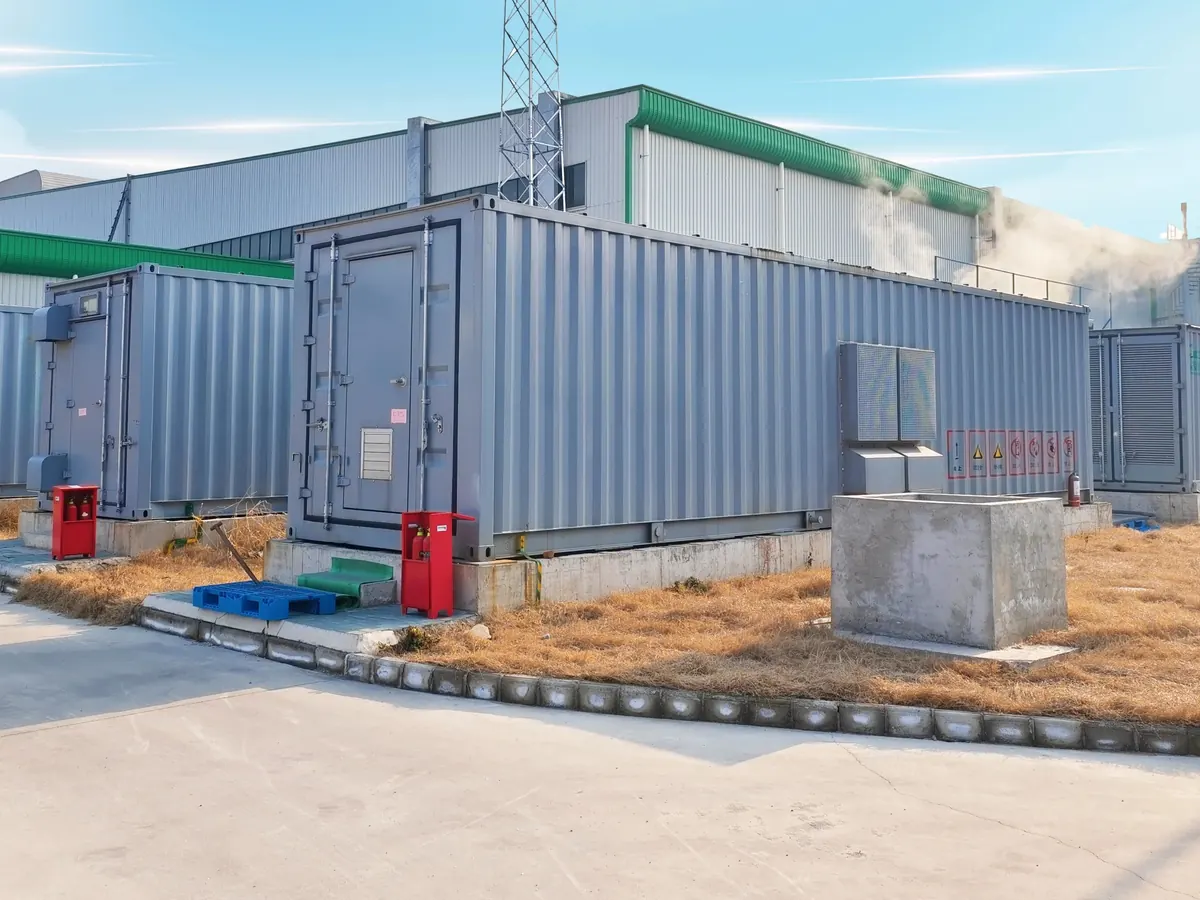 Contenedores de baterías sobre su base de concreto, junto a una nave industrial